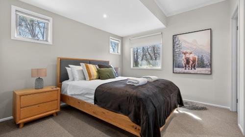 a bedroom with a bed and a picture of a deer at Alpenglow in Dinner Plain