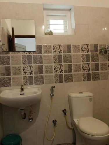 a bathroom with a toilet and a sink at NIRVANA HAVEN HOME STAY in Trivandrum