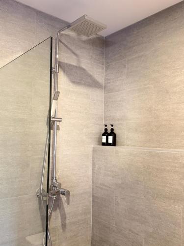 a shower in a bathroom with two bottles on a shelf at Hidden Bay Chaloklam in Chaloklum