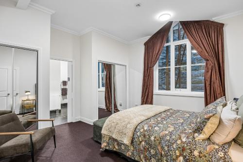 a bedroom with a bed and a window at Chapel On Moray - Apartment in Dunedin