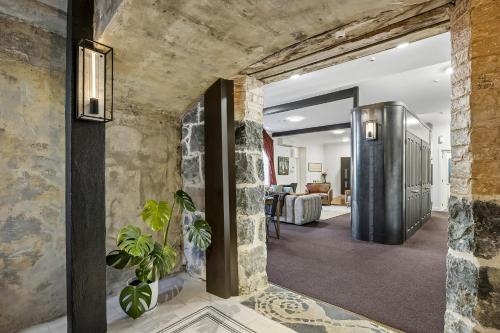 a hallway of a home with a stone wall at Chapel On Moray - Apartment in Dunedin