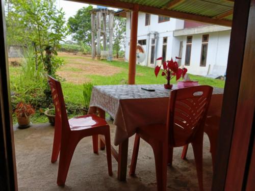 a table and chairs on the porch of a house at Wale Chika Guest House in Tomohon