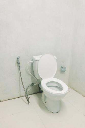 a bathroom with a white toilet in a room at Lavanga Express in Hikkaduwa
