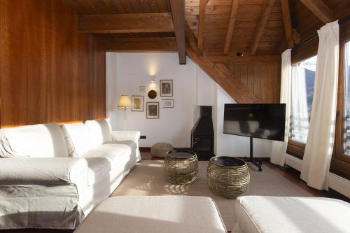 a living room with a white couch and a flat screen tv at Mirador de Sallent by BeValle in Sallent de Gállego