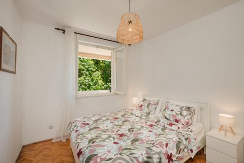 a white bedroom with a bed and a window at Mila in Herceg-Novi