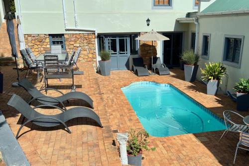 a patio with a pool and a table and chairs at Peace Valley Guesthouse in Napier