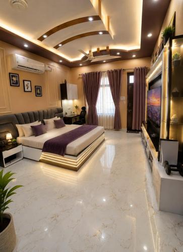a large bedroom with a large bed and a tv at Countrysidecharm in Gwalior