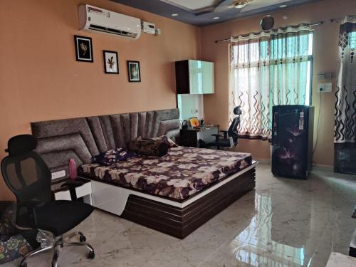 a bedroom with a bed and a desk and a chair at Countrysidecharm in Gwalior