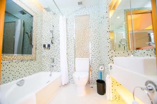 a bathroom with a tub and a toilet and a sink at Dorsett Mongkok, Hong Kong in Hong Kong