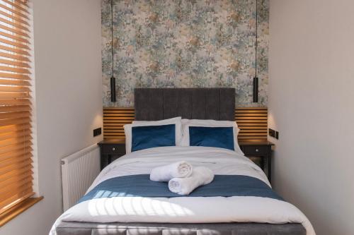 a bedroom with a bed with towels on it at Amber Serviced Rooms - Free parking Self Check-In with access to shared kitchen in Hull
