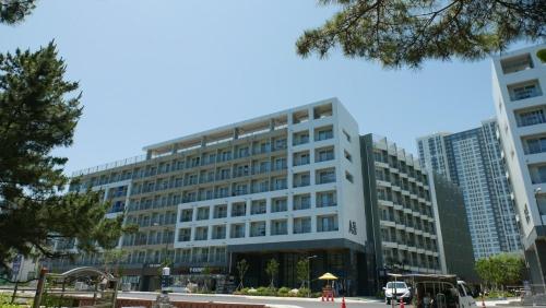 a large building in front of some tall buildings at Sokcho Ocean Beach in Sokcho