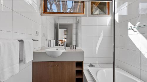 ein weißes Badezimmer mit Waschbecken und Badewanne in der Unterkunft Alpine Walkabout in Dinner Plain