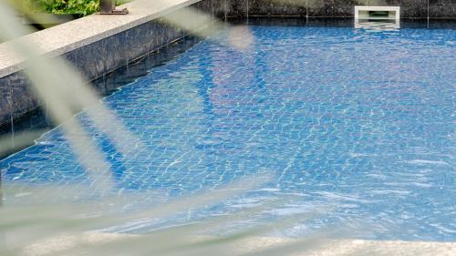 a swimming pool with blue water in a building at Gapyeong The Hill Pool Villa in Gapyeong