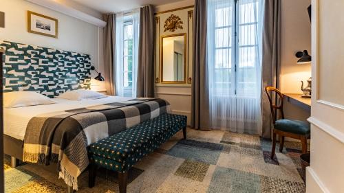 a hotel room with a bed and a chair at Château de Saulon in Saulon-la-Rue