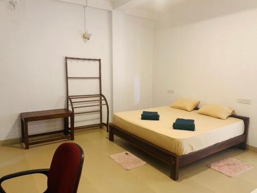 a bedroom with a bed and a chair in it at One More Night Hostel in Sigiriya