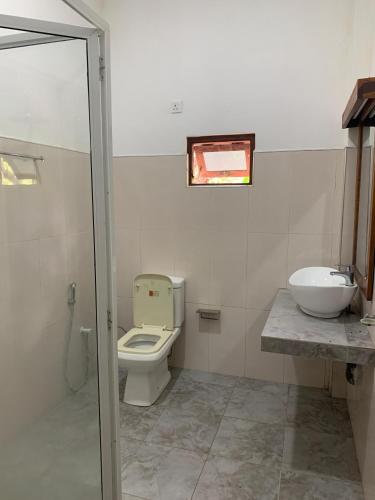 a bathroom with a toilet and a sink at One More Night Hostel in Sigiriya