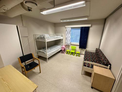 a room with two bunk beds and chairs and a window at Kurimon Majatalo in Kianta