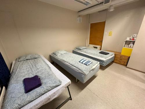 a room with two beds in a hospital room at Kurimon Majatalo in Kianta