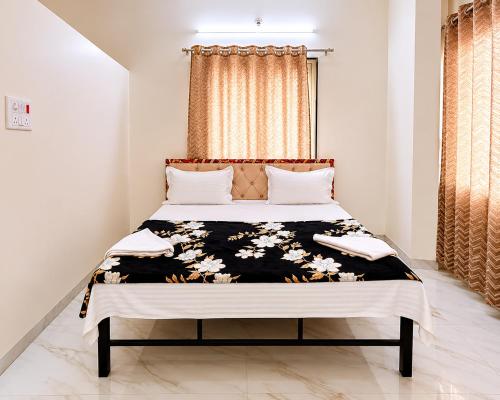 a bedroom with a bed with a black and white comforter at Hotel Prime Lodging in Aurangabad