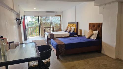 a hotel room with two beds and a table at Lavanga Express in Hikkaduwa