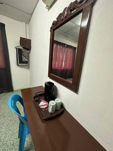 a table with a mirror and two cups on it at planet hotel mersing in Mersing