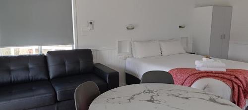 a room with a bed and a couch and a table at Ingenia Holidays Hunter Valley in Cessnock