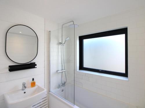 a bathroom with a shower and a sink and a mirror at West Island in Kingsbridge