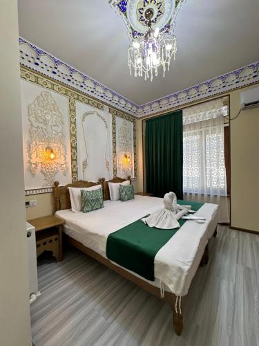 a bedroom with a large bed and a chandelier at Zarhal boutique Premium in Bukhara