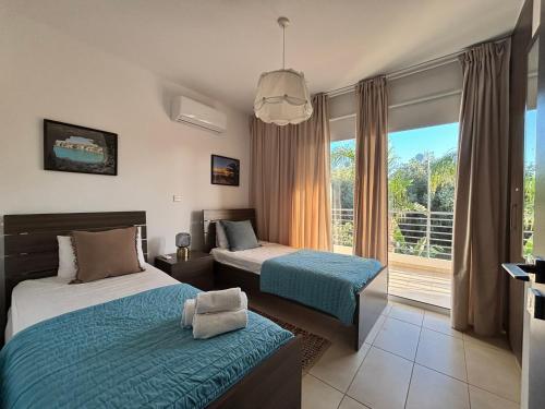 a hotel room with two beds and a window at Domino Blue Apartment in Paralimni