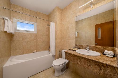 a bathroom with a tub toilet and a sink at Petro Hotel Da Nang in Danang
