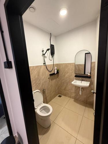 a bathroom with a toilet and a sink and a mirror at Pool View - H&A Signature Klebang in Malacca