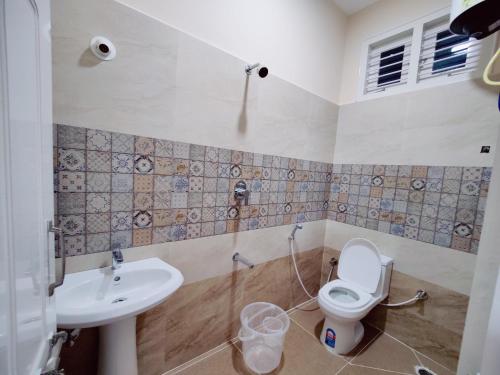 a bathroom with a toilet and a sink at Mysore Studio Rooms in Mysore
