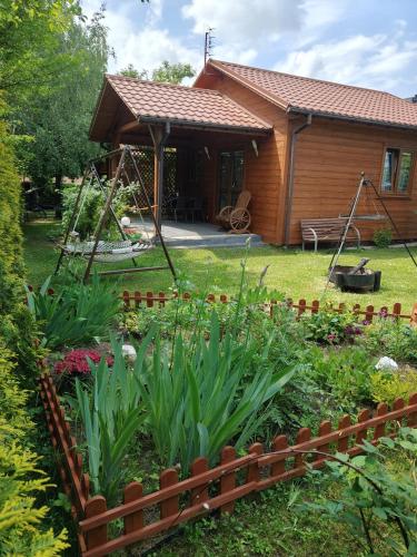 a garden in front of a house with a swing at Nowoczesny Domek Góralski in Kielce