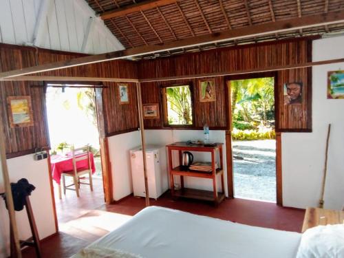a bedroom with a bed and a table with a table at Bungalow Ambanivolo in Sainte Marie