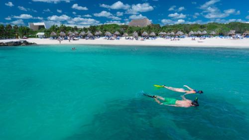 a man laying on his back in the water at a beach at Grand Sirenis Riviera Maya Resort & Spa All Inclusive in Akumal