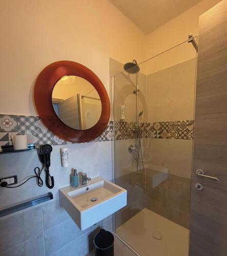 a bathroom with a sink and a shower and a mirror at Affittacamere Nonna Ia in Lustra