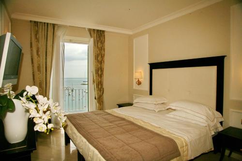 a bedroom with a large bed and a balcony at Hotel Miramare & Spa in Sestri Levante