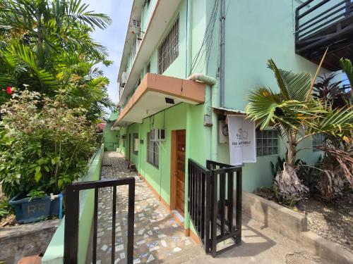 a green building with a gate in front of it at RM Apartments in Idanao