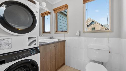 a bathroom with a washing machine and a sink at Freedom in Dinner Plain