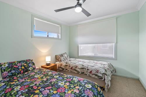 a bedroom with two beds and a window at Tranquility Place in Evans Head