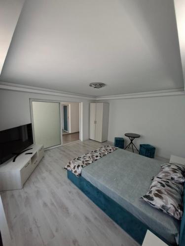 a bedroom with a bed and a flat screen tv at Casa Bon Relax , Rooms&Apartaments in Tuzla