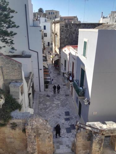 a group of people walking down a street with buildings at Missipezza Residence a Frassanito in Alimini