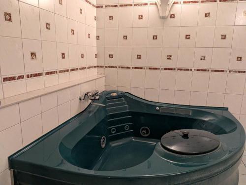 a bathroom with a green tub with a toilet in it at HotelG7 in Tokyo