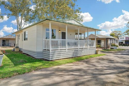 a small white house with a white porch at Ingenia Holidays Hunter Valley in Cessnock