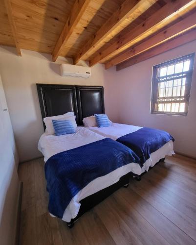 a bedroom with two beds in a room with wooden ceilings at Unpretentious peaceful Cottage in Clanwilliam