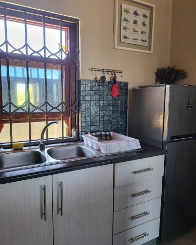 a kitchen with a sink and a refrigerator at Unpretentious peaceful Cottage in Clanwilliam
