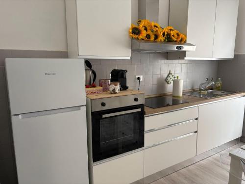 a kitchen with white cabinets and a stove top oven at I Tulipani in Genoa