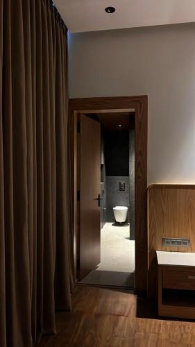 a bathroom with a door leading to a bathroom with a toilet at Hotel Meridien Riverfront in Srinagar