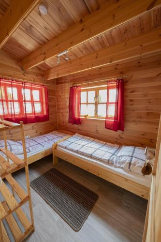 a room with two bunk beds in a log cabin at Camping Seewiese in Pfedelbach