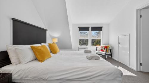 a bedroom with a large white bed with yellow pillows at Humffray 3 in Dinner Plain